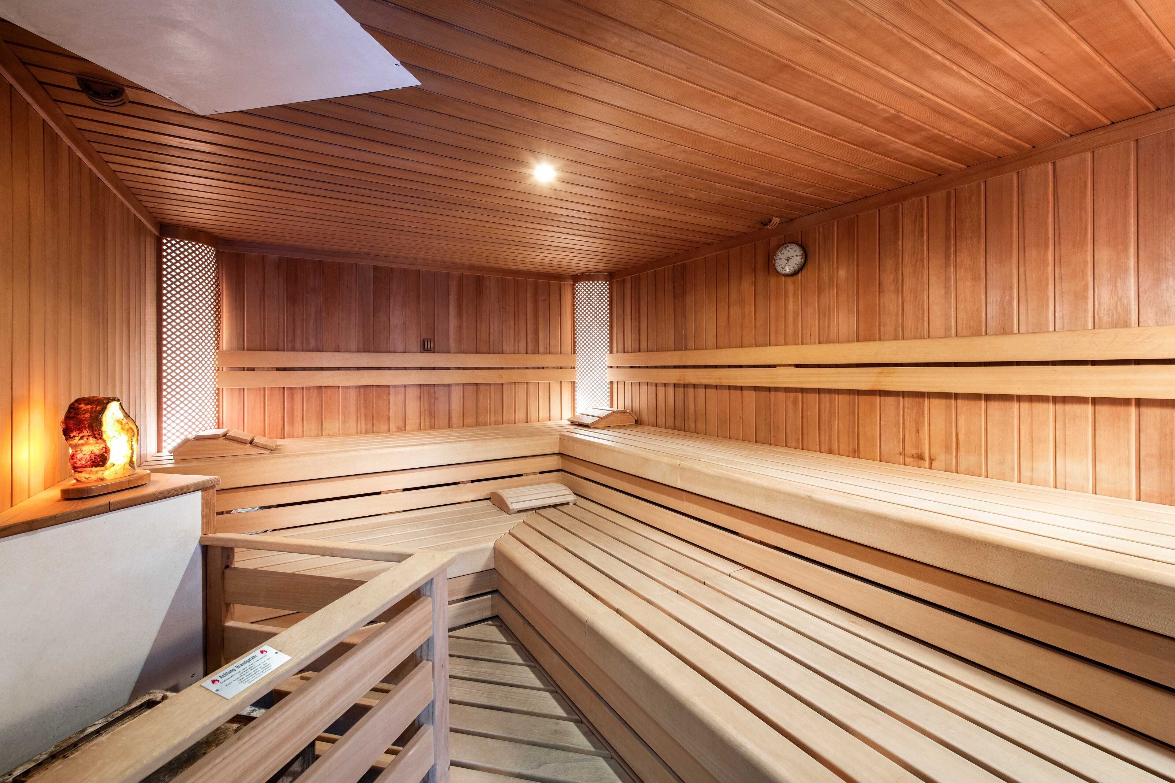 Una sauna con bancos de madera y un calentador para bancos.