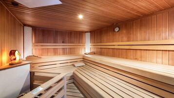 Una sauna con bancos de madera y un calentador para bancos.
