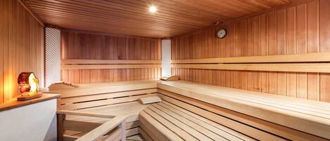 Una sauna con bancos de madera y un calentador para bancos.