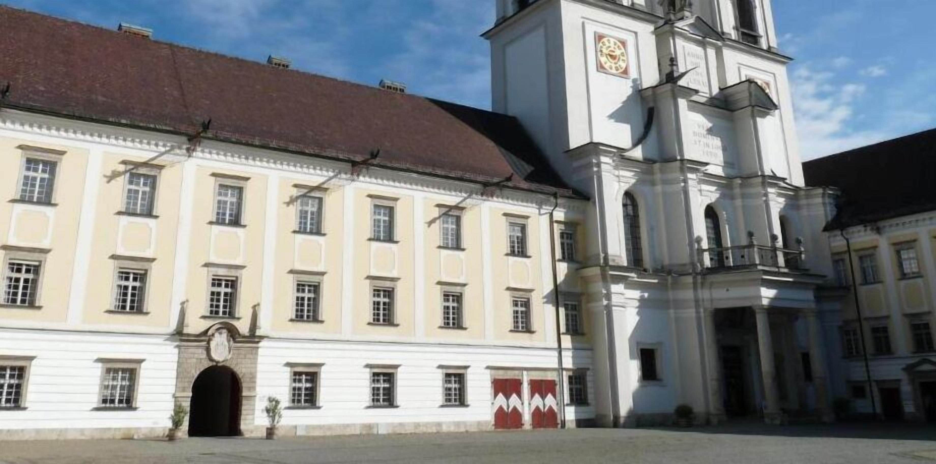 A historic building with a clock tower, large windows, and a central entrance.