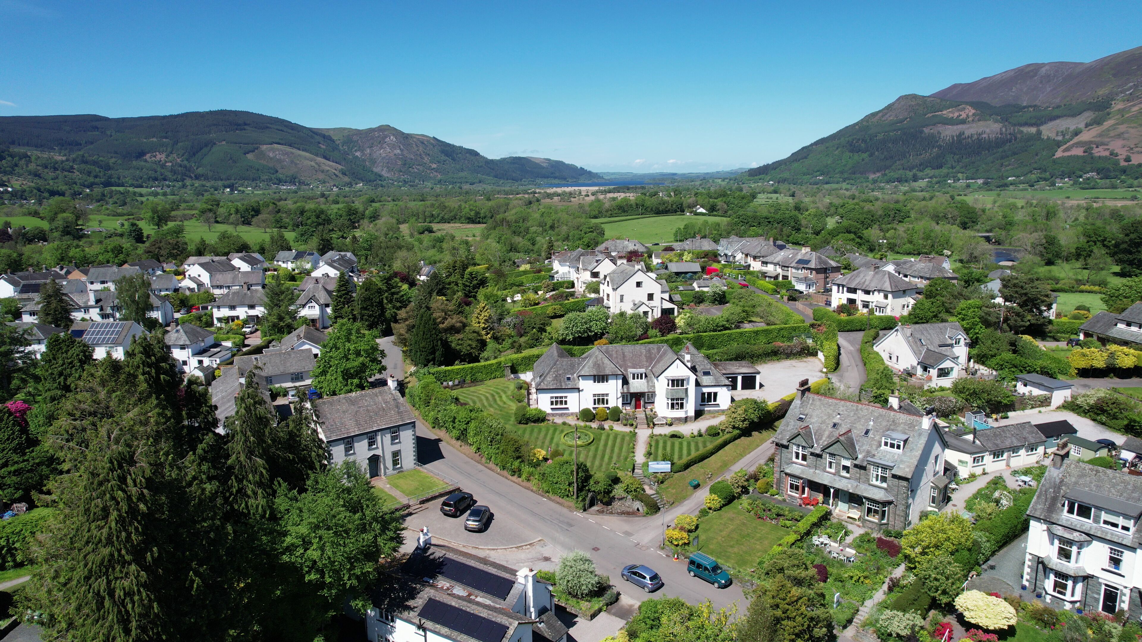 Zona residencial con casas, carreteras y montañas al fondo.