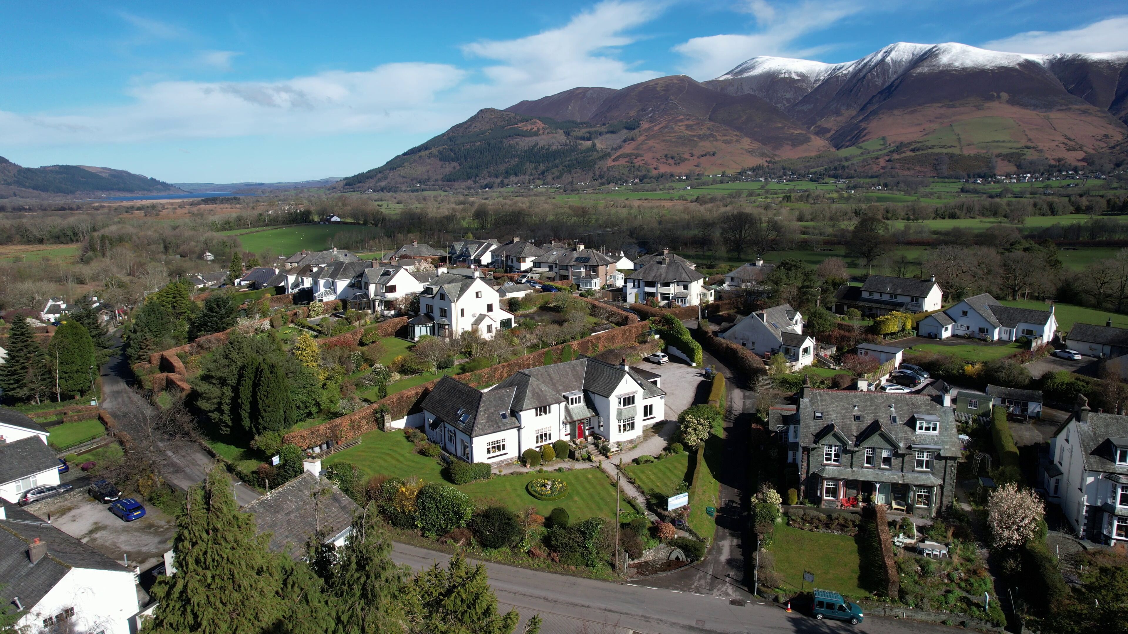 A residential area with houses, a road, and a mountain in the background.