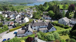 A residential area with houses, a parking lot, and a lake in the background. - Dalegarth House (Keswick)