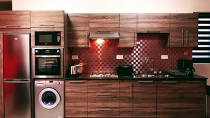 Eine moderne Küche mit Edelstahlgeräten, Holzschränken und einer karierten Spritzschutzwand.