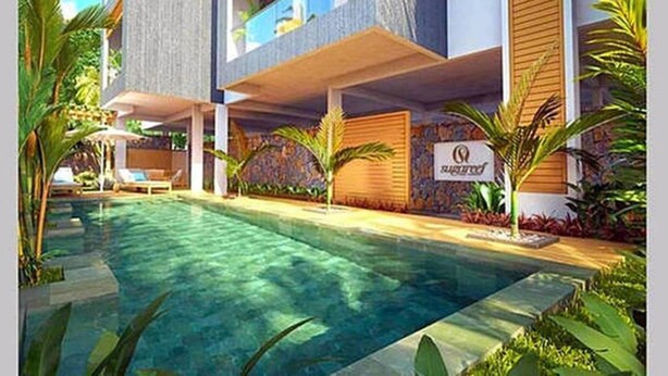 Ein modernes Hotel mit Schwimmbad, Außenbereich und üppiger Bepflanzung.