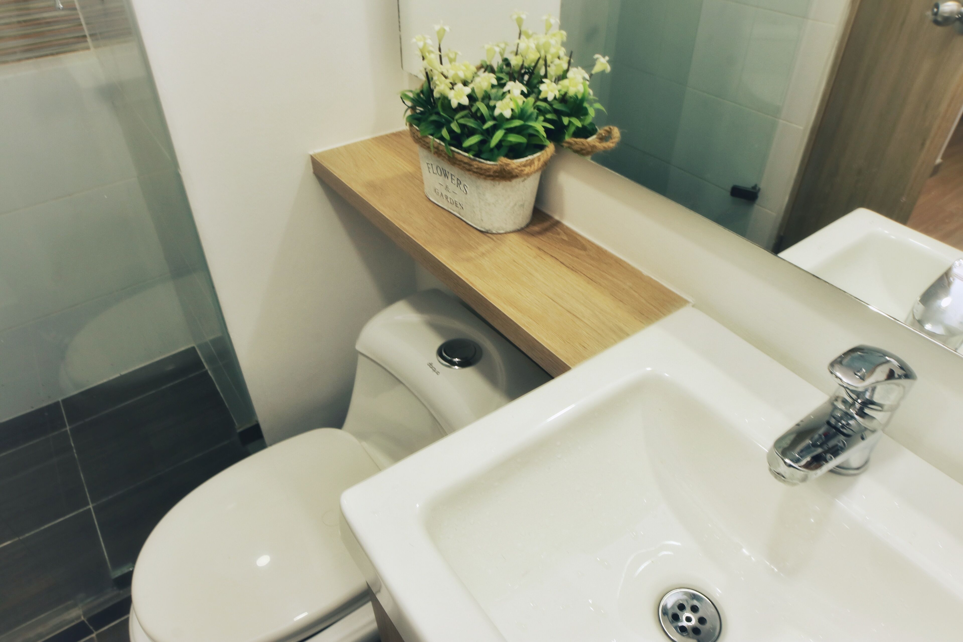 Un baño con inodoro, lavamanos y espejo.