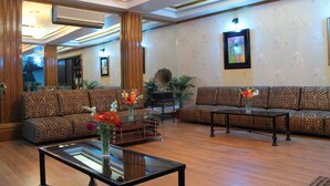 A spacious lobby with patterned sofas, a coffee table, and a large mirror. - Hotel De Meridian (Dhaka)