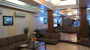 A spacious lobby with a large seating area, a chandelier, and a television on the wall. - Hotel De Meridian (Dhaka)