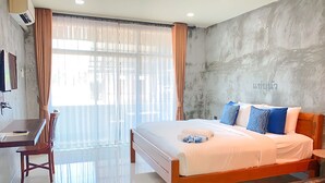 Quarto de hotel moderno com uma cama grande, uma escrivaninha e uma cadeira.