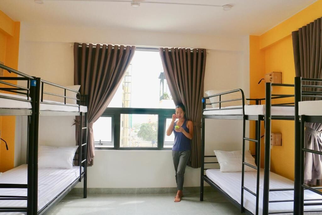 Un dormitorio con literas, una ventana con cortinas y vista al exterior.