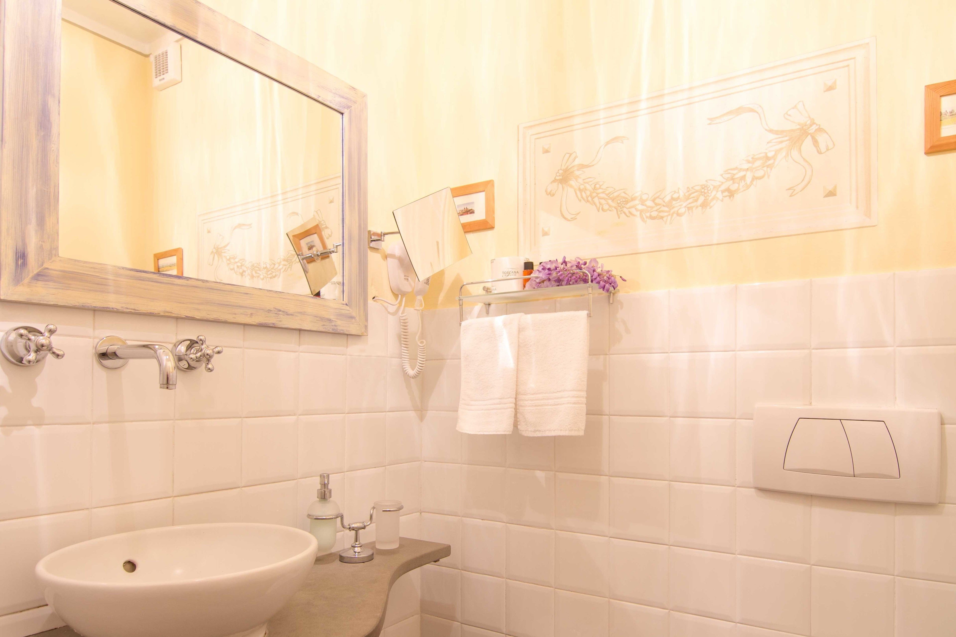 A bathroom with a sink, mirror, and towel rack.