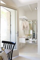 Un baño luminoso y moderno con un espejo grande, un perchero para toallas y un lavamanos.
