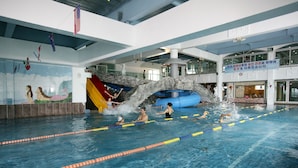 An indoor swimming pool with multiple lanes, a water slide, and a mural on the wall. - The Blue Guesthouse - Hostel (Busan)