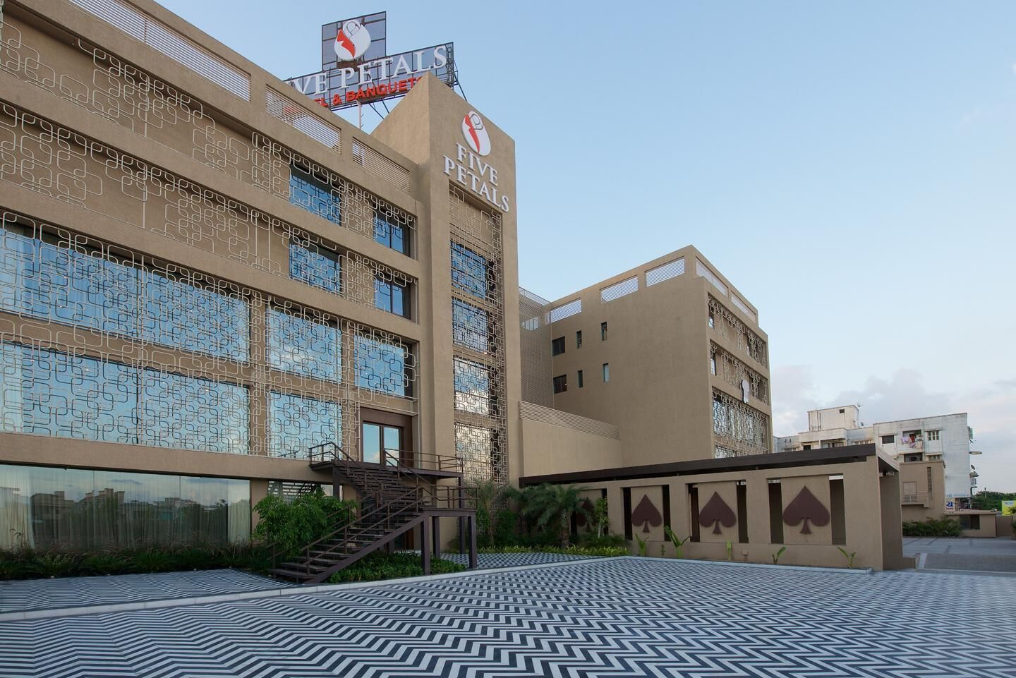 A hotel with a modern facade, a visible staircase, and a patterned floor.