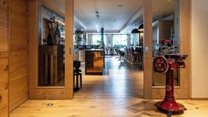 A wooden interior with a kitchen area, a dining space, and a red antique machine. - Hotel Ruland (Altenahr)