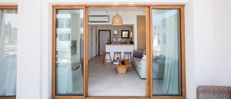 A modern living space with a sliding glass door leading to a kitchen area.