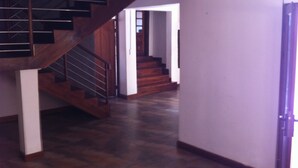 Una escalera de madera con barandillas de metal que conduce a una puerta.