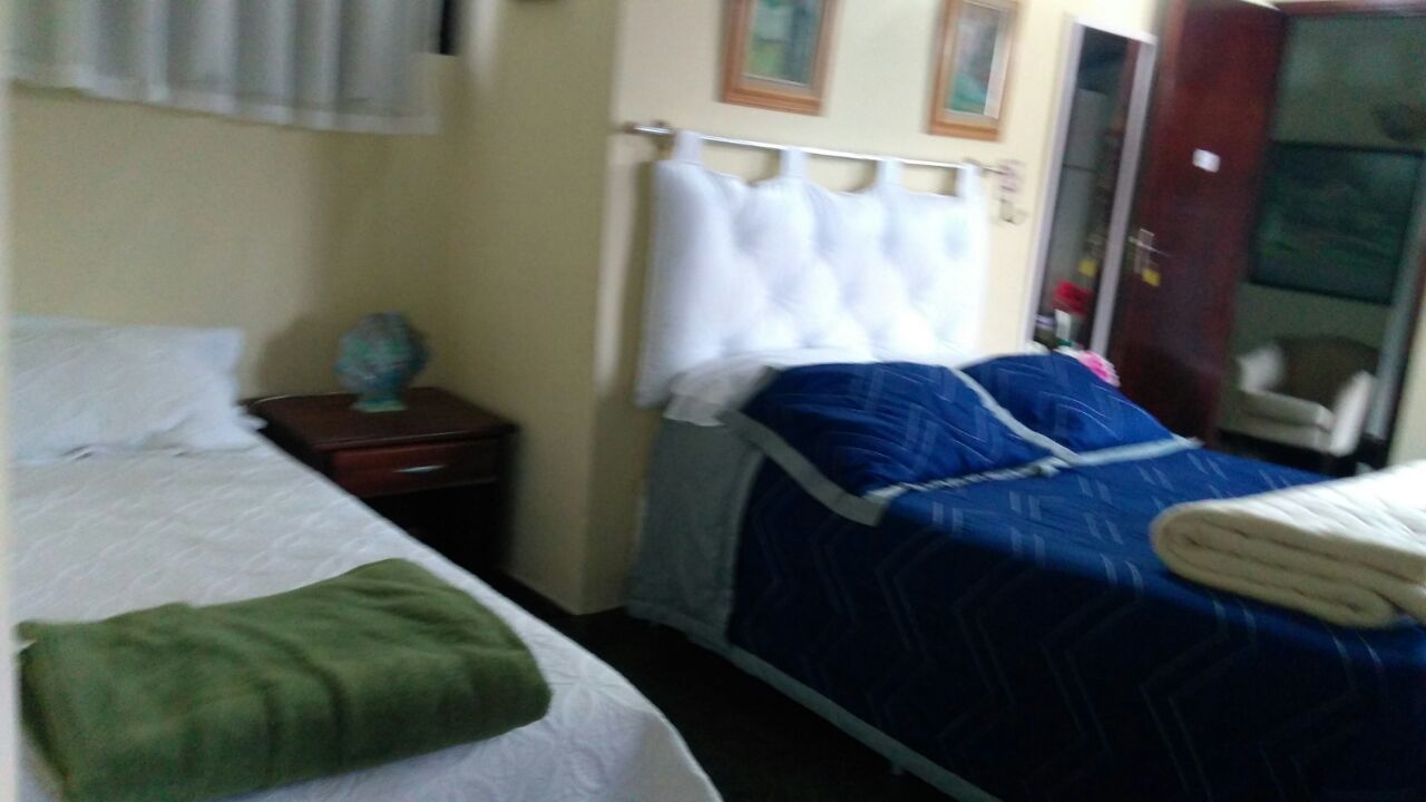 Habitación de hotel con dos camas, una mesita de noche y un armario.
