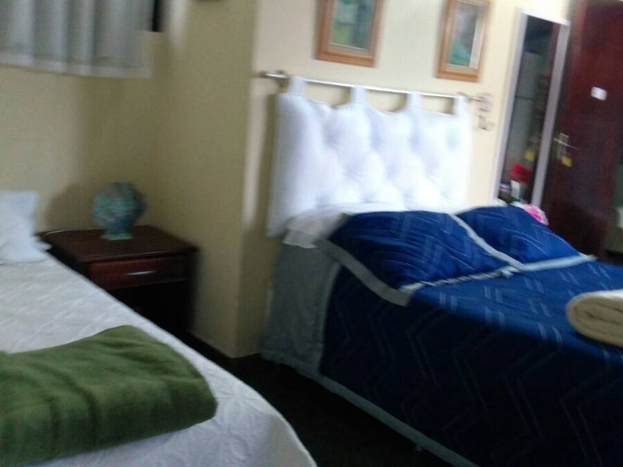 Habitación de hotel con dos camas, una mesita de noche y un armario.