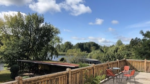 A wooden deck with a view of a lake and forest.