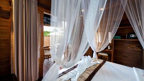 A bedroom with a bed, a wooden wardrobe, and a nightstand.