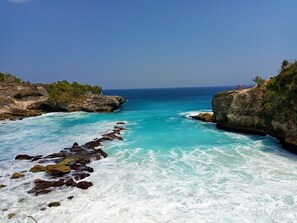 Un paysage côtier avec des falaises rocheuses et des eaux turquoise.