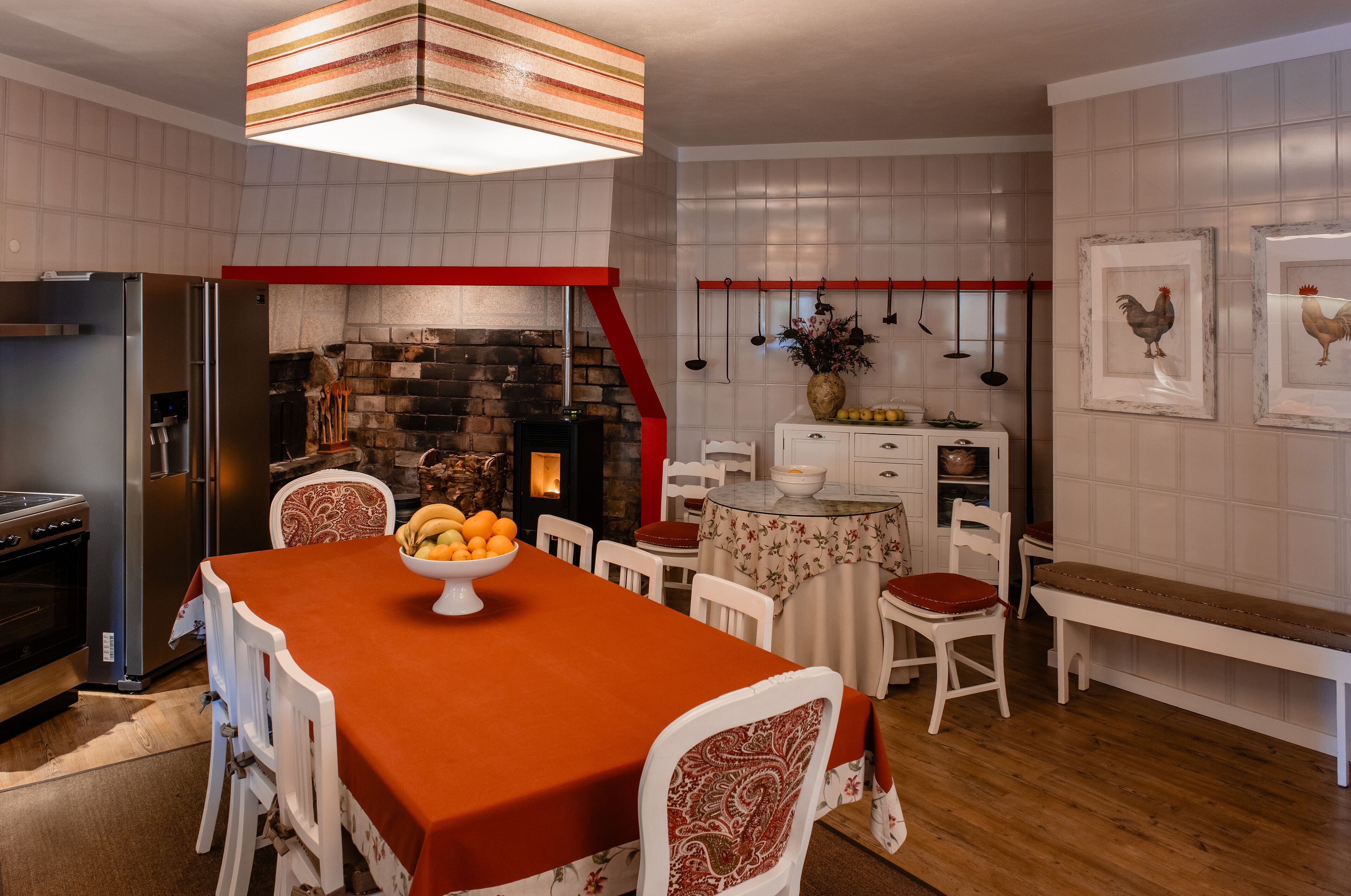 Una cocina moderna con una isla central, horno empotrado y una lámpara colgante.