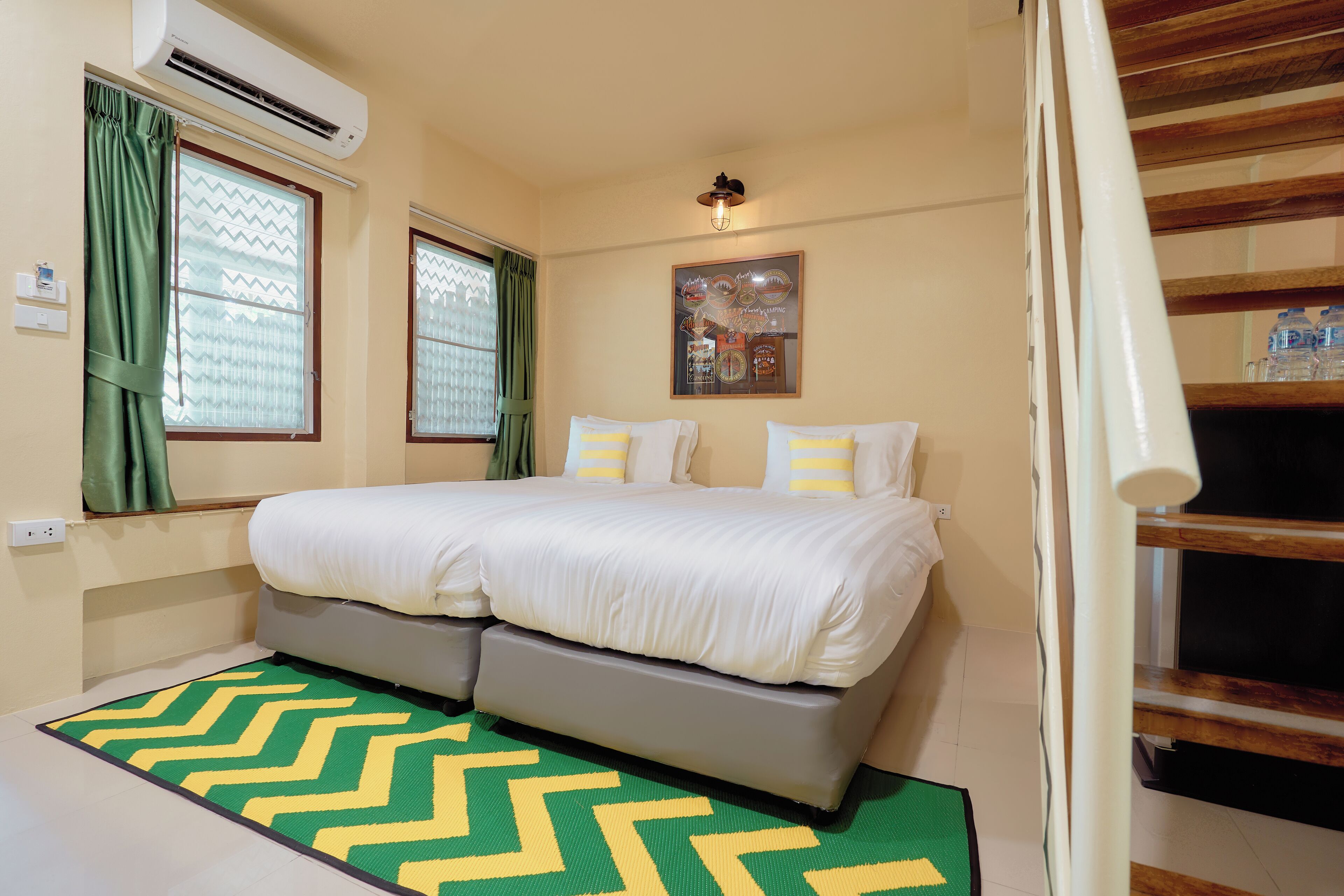 A bedroom with a bed, air conditioning unit, and a window with curtains.