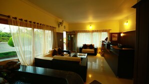 A hotel room with a living area, a dining table, and a kitchen area. - Holiday Heaven Munnar (Devikolam)