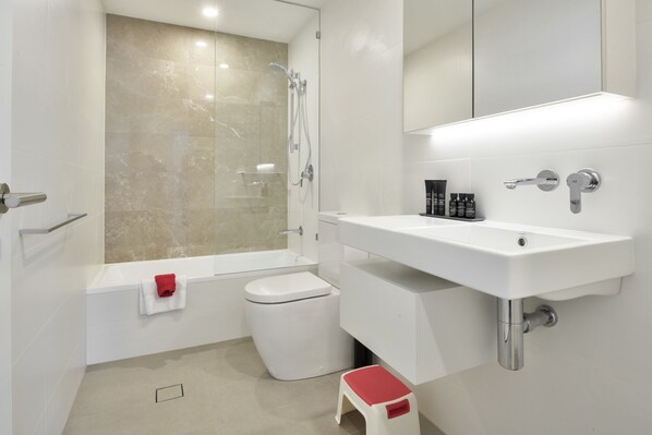 A modern bathroom with a bathtub, toilet, and sink.