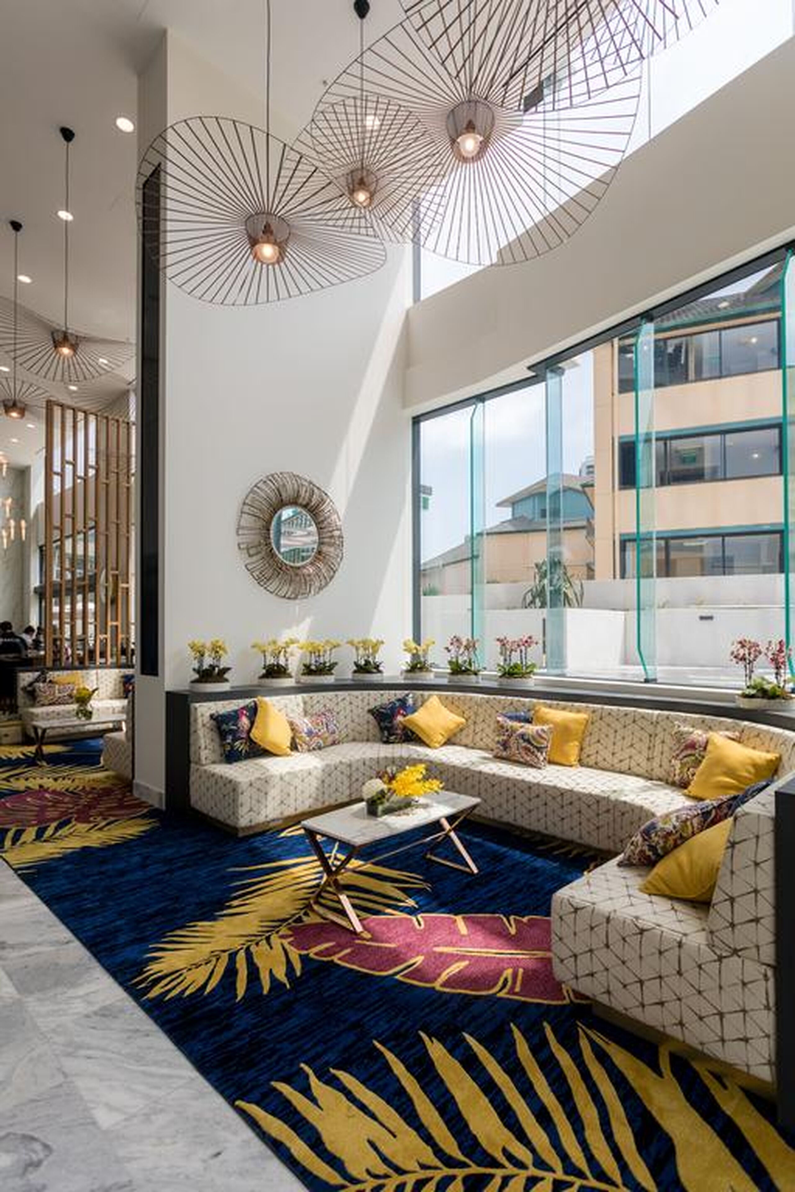 Een moderne hotel lobby met een ruim zithoek, een kamerbreed tapijt en een groot raam met uitzicht.