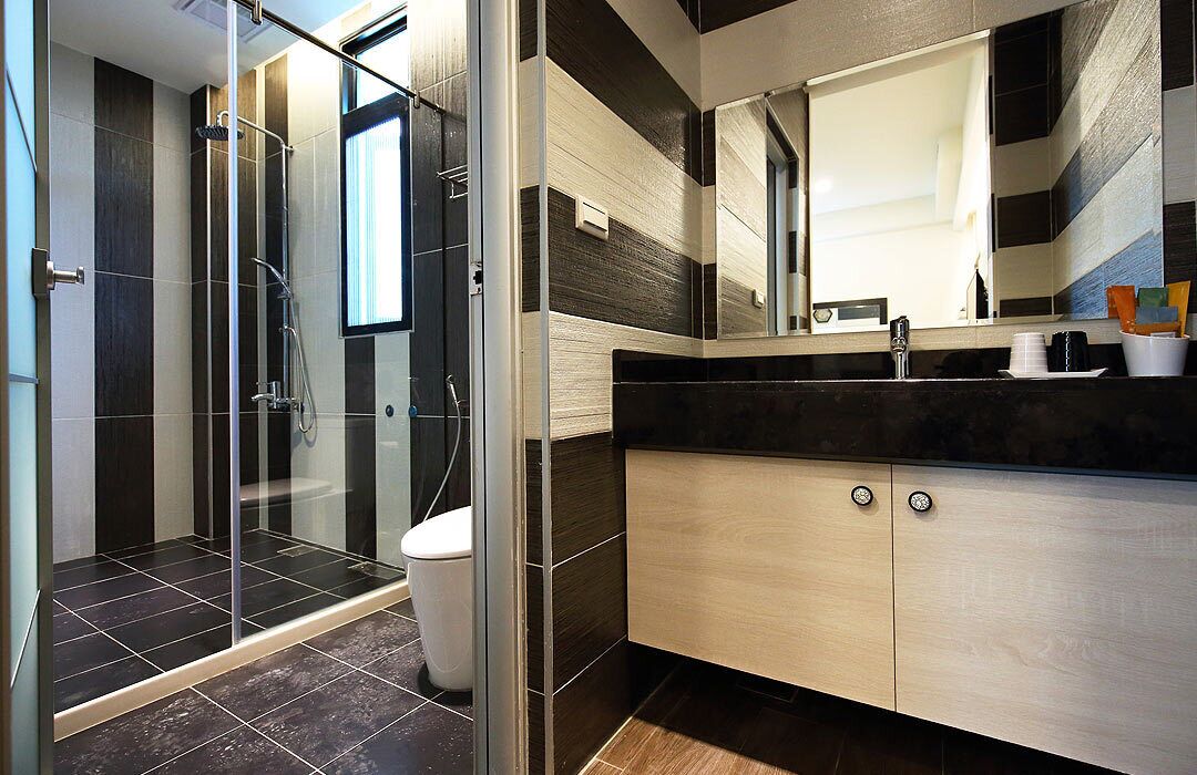 Un bagno moderno con cabina doccia in vetro, un water e un mobile lavabo con specchio e lavandino.