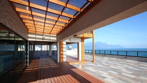 A spacious outdoor area with a wooden deck, glass walls, and a view of the sea and mountains. - Seven Stars Sunrise, Seven Stars DEAR (Hualien City)