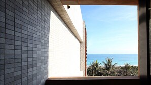 A view from a window overlooking a beach with palm trees and the ocean. - Seven Stars Sunrise, Seven Stars DEAR (Hualien City)