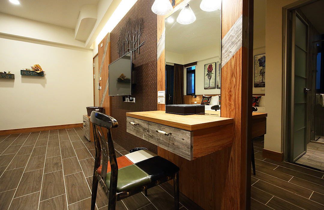 Un baño con tocador de madera, espejo y una silla.