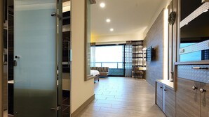 A modern hotel room with a sliding door, a balcony with a view, and a dining area with a table and chairs. - Seven Stars Sunrise, Seven Stars DEAR (Hualien City)