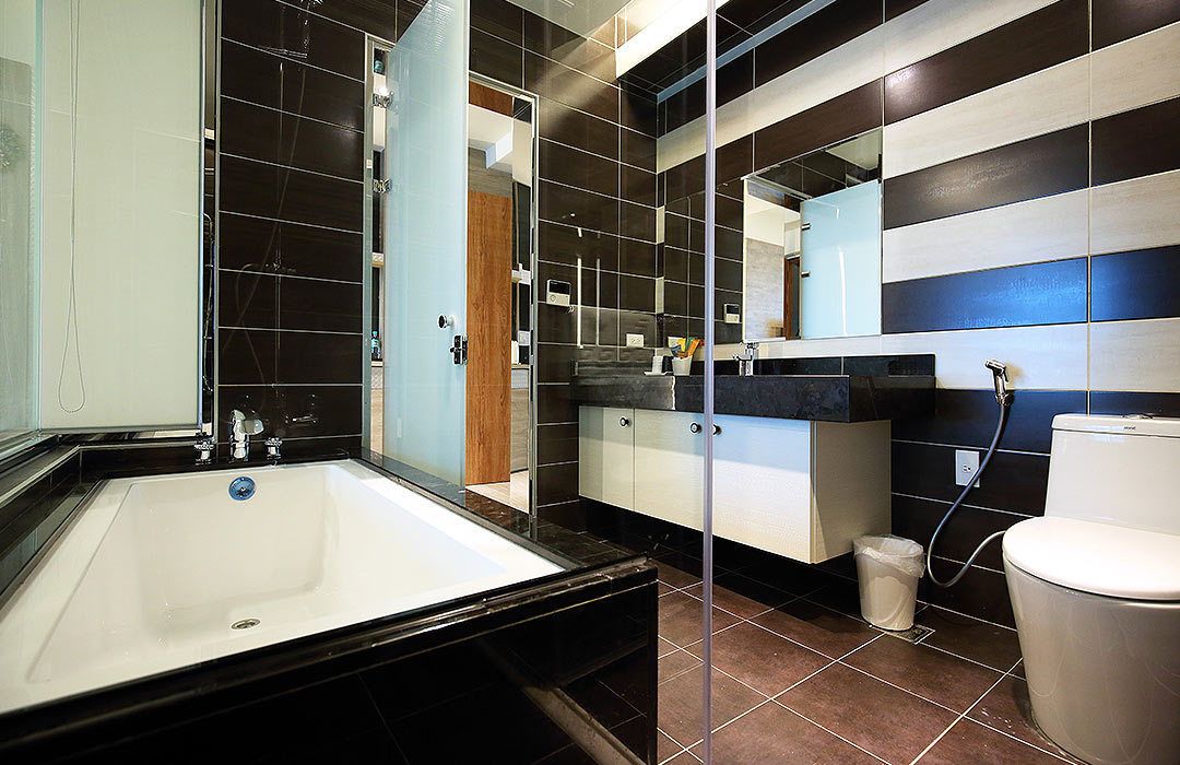 A modern bathroom with a large bathtub, a toilet, and a sink.