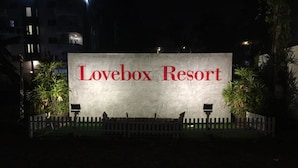 A sign for Lovebox Resort with a white background and red lettering. - Love Box Resort (Bang Phli)