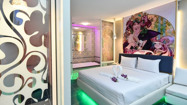 A modern hotel room with a bed, a decorative wall mural, and a shower area. - Relax Villa Hotel (Samut Prakan)