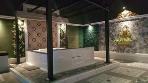 A modern bathroom with a freestanding bathtub, green wall decor, and a decorative wall piece. - Relax Villa Hotel (Samut Prakan)