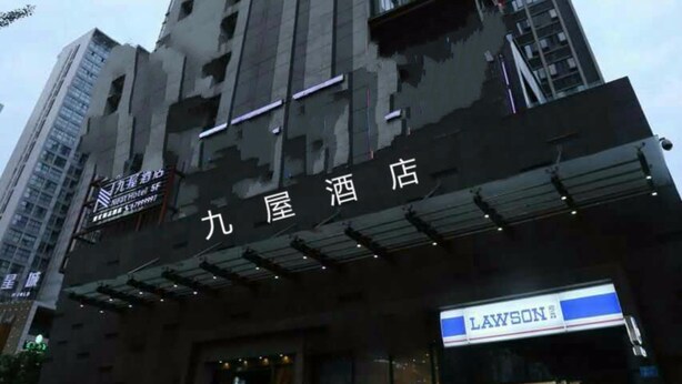 Un hotel moderno de gran altura con una entrada destacada y señalización.