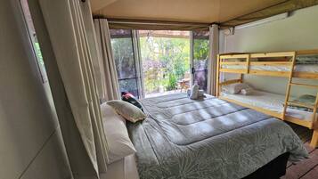 Tienda de campaña, varias camas, baño privado, vista al jardín | Ropa de cama