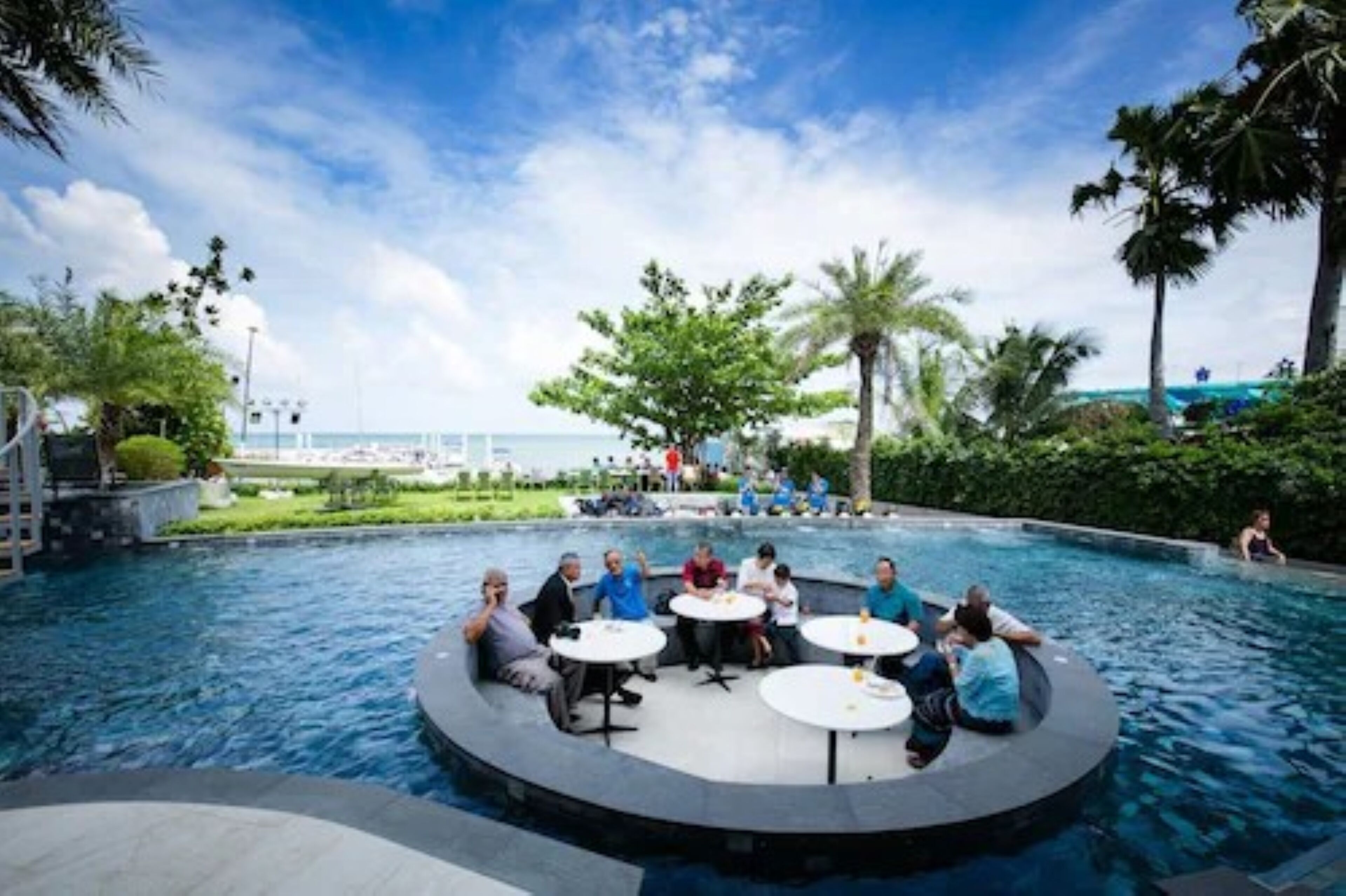 A poolside area with a circular seating arrangement and a view of the ocean.