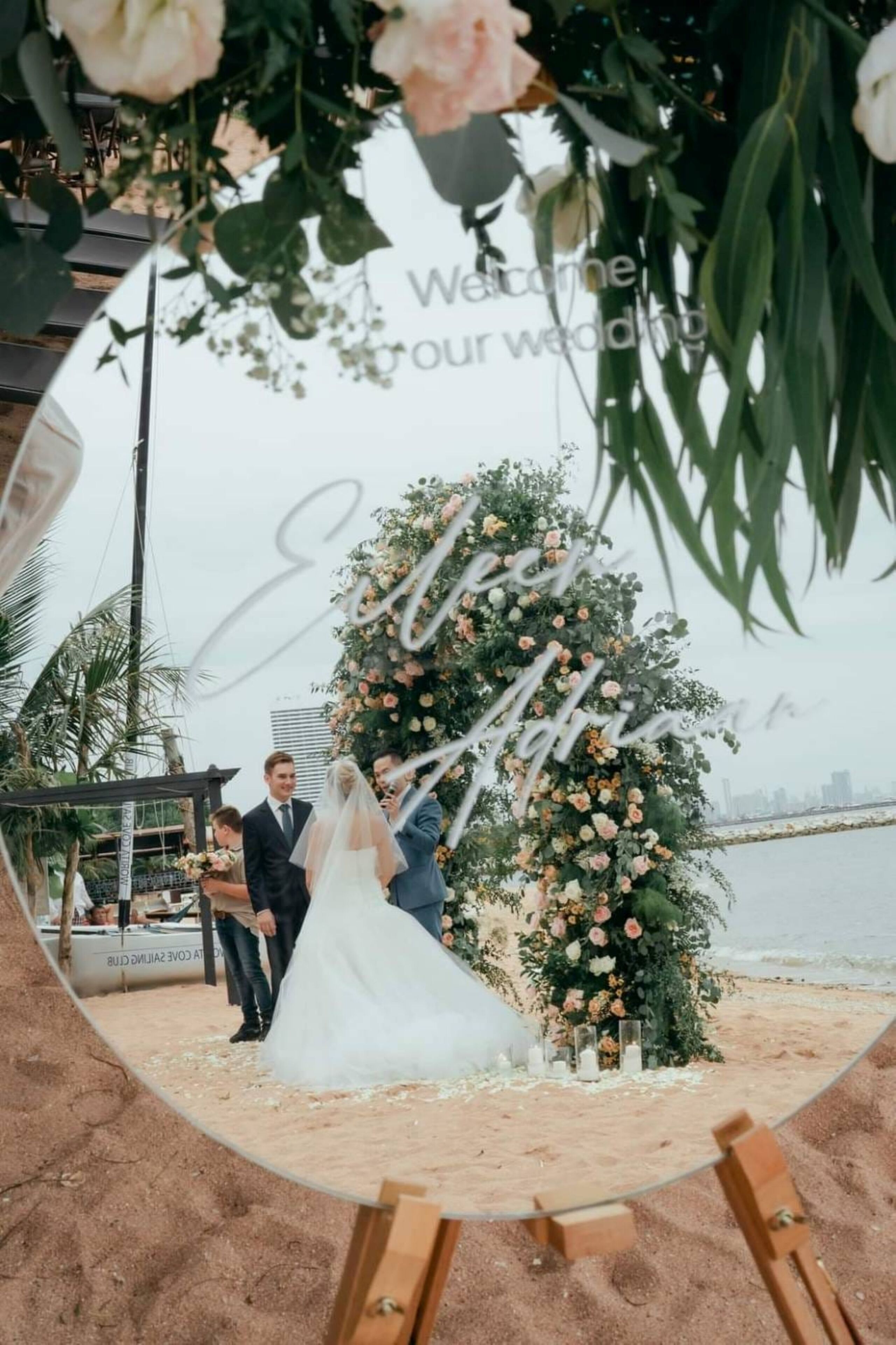 Cerimônia de casamento com um arco de flores e vista para o horizonte da cidade.