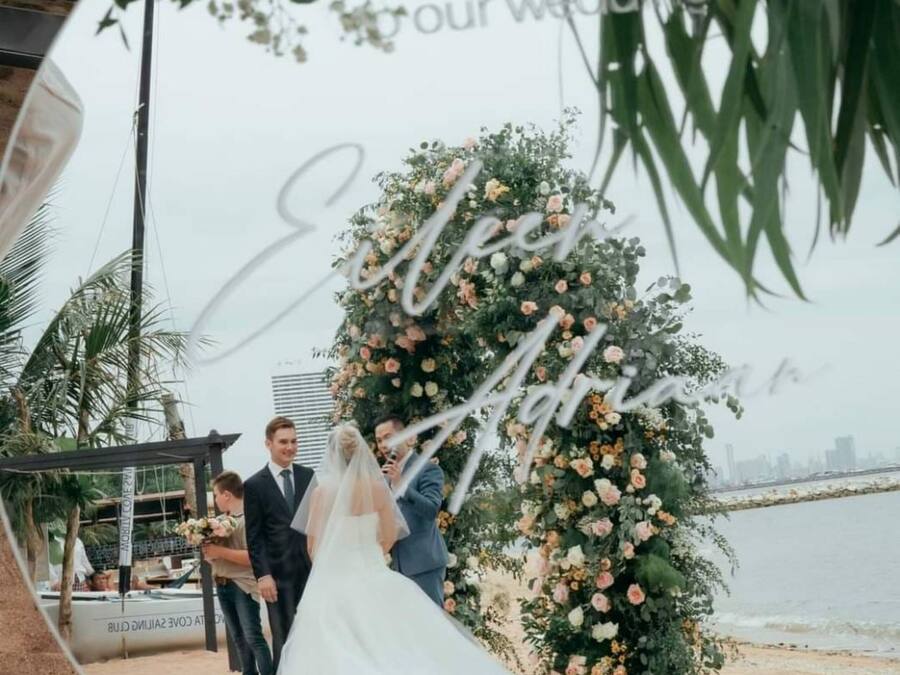 Cerimônia de casamento com um arco de flores e vista para o horizonte da cidade.