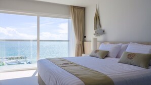 Une chambre d’hôtel avec un grand lit, une vue sur l’océan et un balcon.