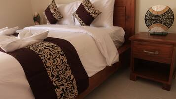A neatly made bed with patterned pillows and a decorative headboard.