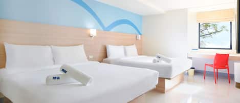 A hotel room with two beds, a wooden headboard, a red chair, and a window with a view of trees.