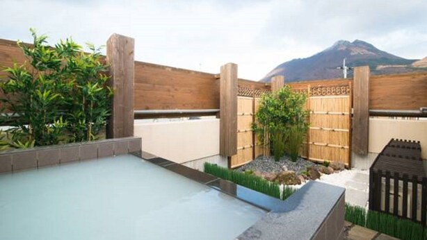 A rooftop pool area with a wooden fence, a small garden, and a mountain view. - Etavia Yufuin ekimae (Yufu)