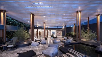 Relax in style with plush seating and a serene pool area, surrounded by artwork and lush greenery.